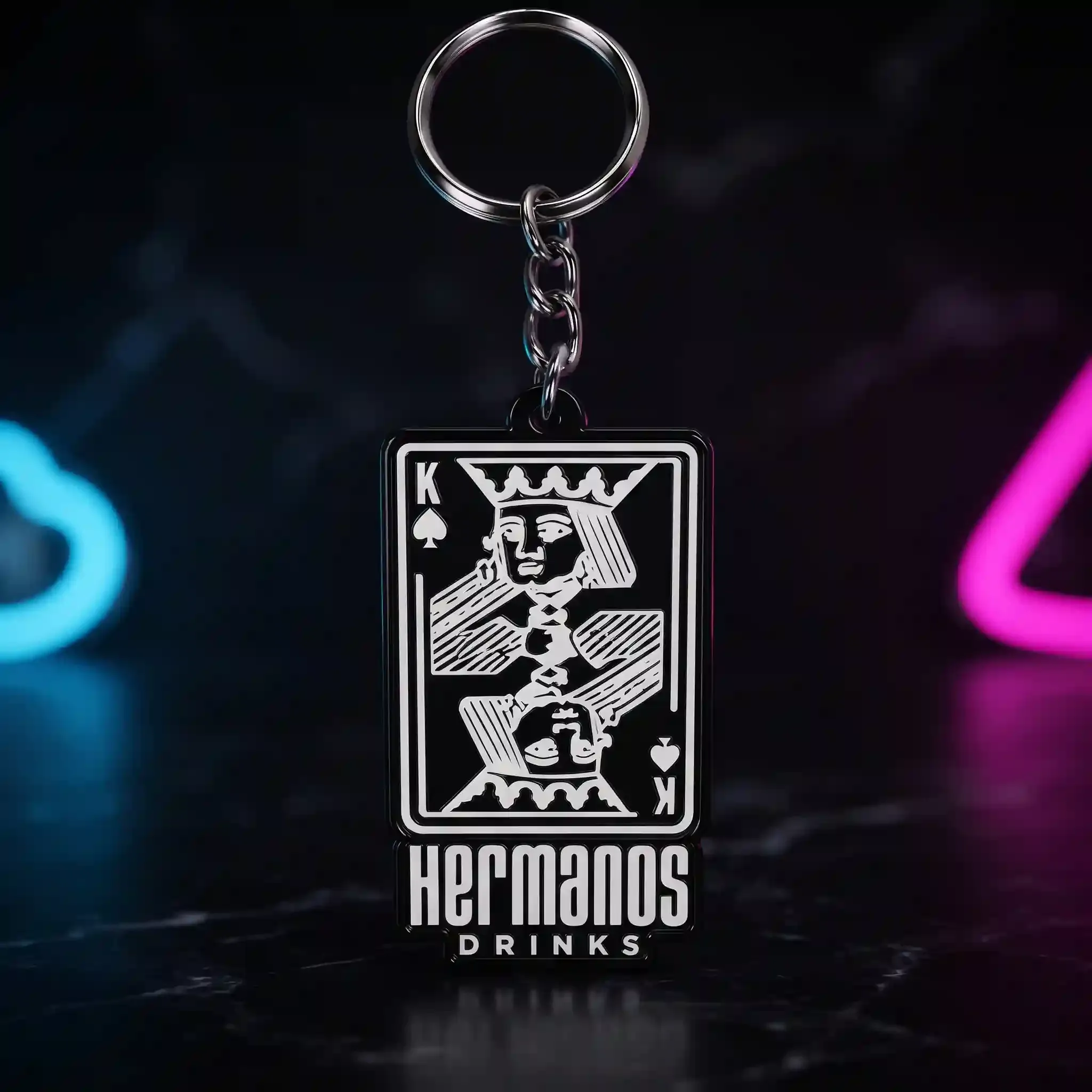 Llavero Hermanos Drinks — La carta del rey recortada en llavero, con el logo debajo